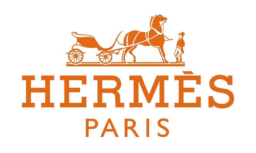 The official logo for the Hermès brands features an orange silhouette of a horse-drawn carriage with a standing groom, positioned above the word "HERMÈS" in bold, sans-serif orange letters. Below "HERMÈS," the word "PARIS" is written in smaller, orange letters, all set against a clean white background.