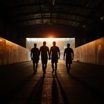 Cinematic banner showing silhouettes of soccer players walking down a stadium tunnel, symbolizing legends retiring after the 2026 World Cup.