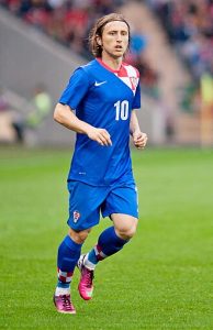 Luka Modric playing for the Croatia National Team in a blue away kit with number 10 during a match against Portugal in 2013.