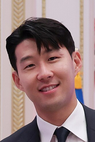 Portrait of Son Heung-min, South Korea national team captain, smiling in formal attire.