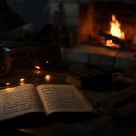 Vintage sheet music open on a rustic wooden desk illuminated by warm string lights and a glowing fireplace in the background, setting a cozy nostalgic mood.