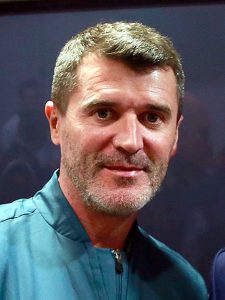 Close-up portrait of Roy Keane from 2014, one of football's legendary captains, looking directly at the camera wearing a dark teal zip-up jacket.