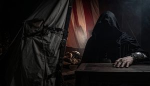 A shadowy, mysterious figure claiming to be the dead Emperor sits completely obscured in darkness